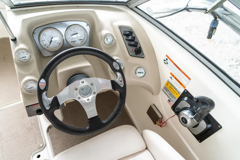 Slide: The Image of 2010 Larson LX 1850 boat dashboard with steering wheel and control panel. - 14