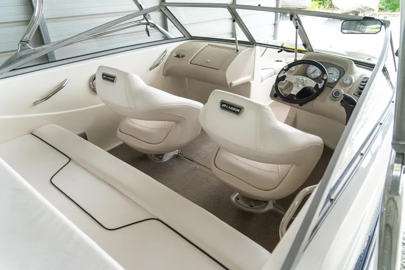 Slide: The Image of 2010 Larson LX 1850 boat interior with white seats and steering console. - 15