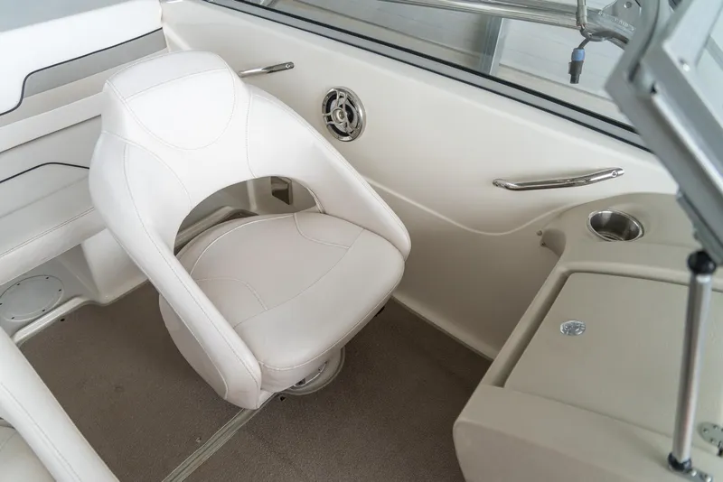 Slide: The Image of 2010 Larson LX 1850 boat interior with white captain's chair and beige carpet. - 18