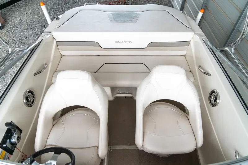 Slide: The Image of 2010 Larson LX 1850 boat interior with two white seats and storage compartment. - 19