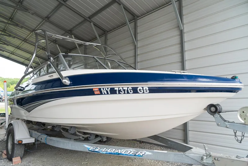 Slide: The Image of 2010 Larson LX 1850 boat on trailer in covered storage. - 5