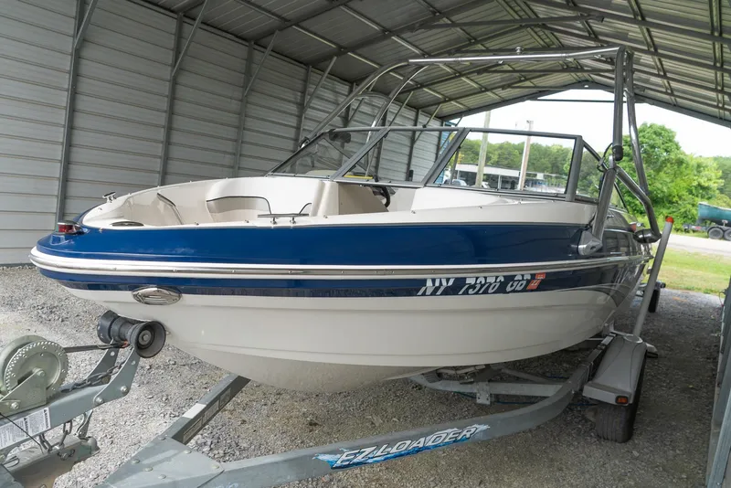 Slide: The Image of 2010 Larson LX 1850 boat on trailer under metal shelter. - 7