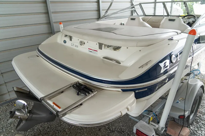 Slide: The Image of 2010 Larson LX 1850 boat in storage, rear view with swim platform and ladder. - 9