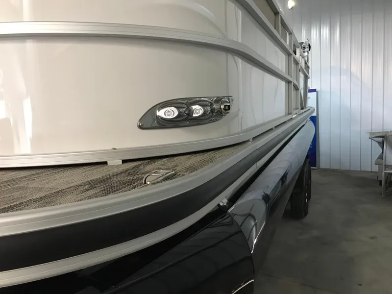 Slide: The Image of 2024 Ranger Reata 243C pontoon boat in a storage facility. - 12