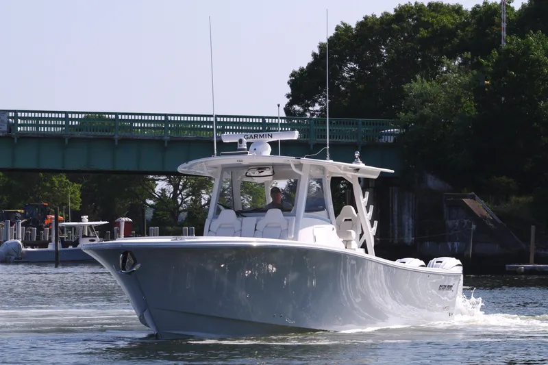 Slide: The Image of 2025 Regulator 37 boat cruising on a river near a green bridge. - 12