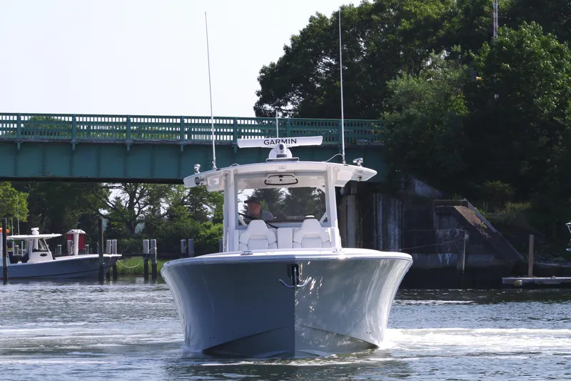 Slide: The Image of 2025 Regulator 37 boat cruising under a bridge on a sunny day. - 13