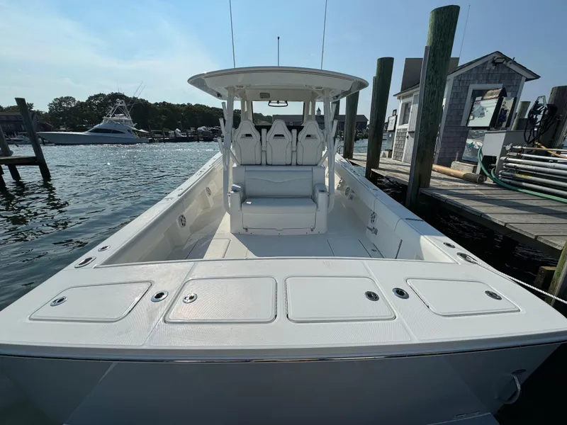 Slide: The Image of 2025 Regulator 37 boat docked at a marina, showcasing spacious deck and seating. - 16