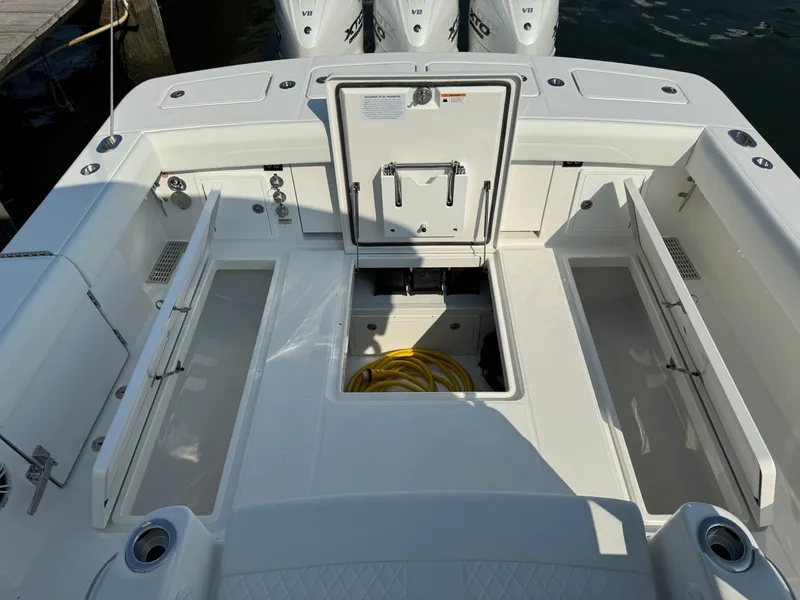 Slide: The Image of 2025 Regulator 37 boat deck with open storage compartments and visible engine access. - 24