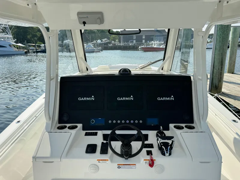 Slide: The Image of 2025 Regulator 37 boat helm with Garmin navigation system at a marina. - 34