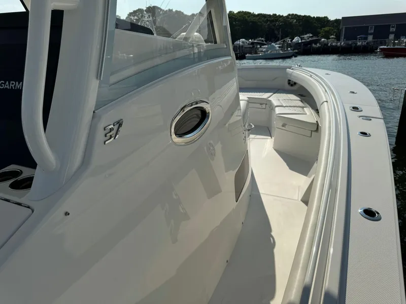 Slide: The Image of 2025 Regulator 37 boat, sleek white exterior, docked by the water. - 44