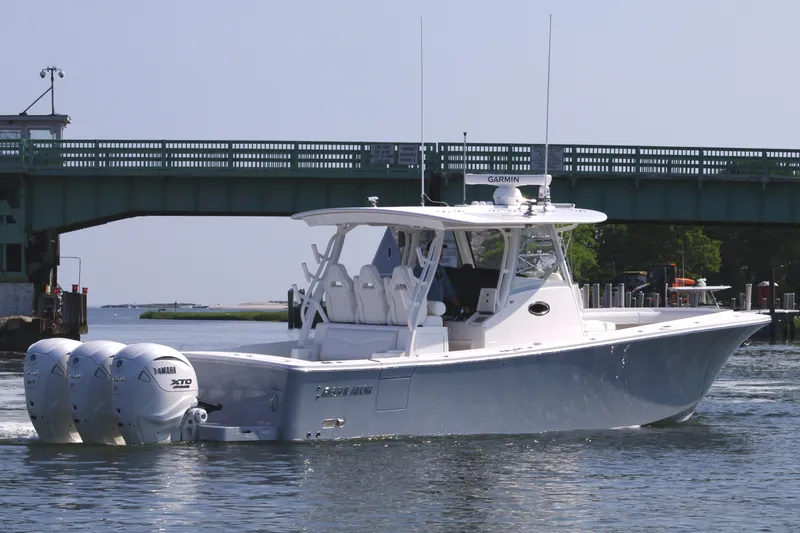 Slide: The Image of 2025 Regulator 37 boat cruising under a bridge on a sunny day. - 6
