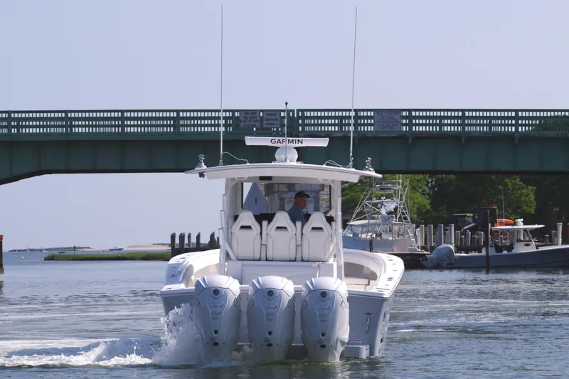 Slide: The Image of 2025 Regulator 37 boat with triple outboard engines under a bridge. - 8