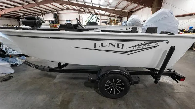 Slide: The Image of 2025 Lund 1650 Rebel XL SS fishing boat on trailer in warehouse. - 7