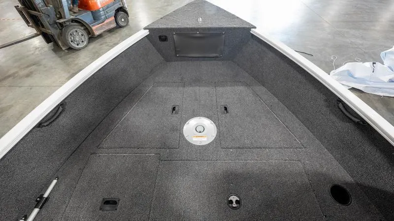 Slide: The Image of 2025 Lund 1650 Rebel XL SS boat interior with gray carpeted deck. - 8