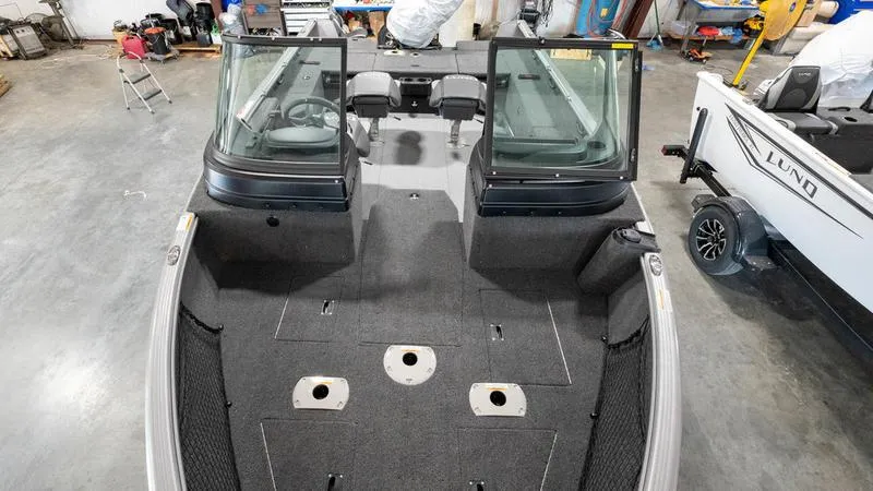 Slide: The Image of 2024 Lund 1875 Impact XS Sport boat interior in a garage. - 29