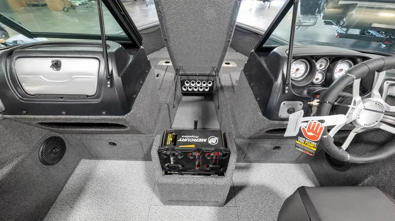 Slide: The Image of 2024 Lund 1875 Impact XS Sport boat interior, featuring dashboard and battery compartment. - 3