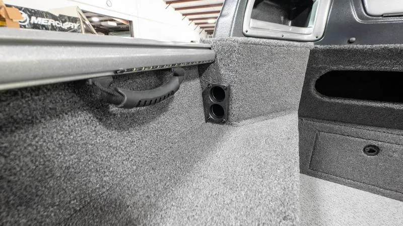 Slide: The Image of 2024 Lund 1875 Impact XS Sport interior detail with carpeted finish and storage compartments. - 5