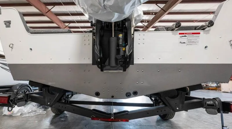 Slide: The Image of 2024 Lund 1875 Impact XS Sport boat transom and trailer in a warehouse. - 6