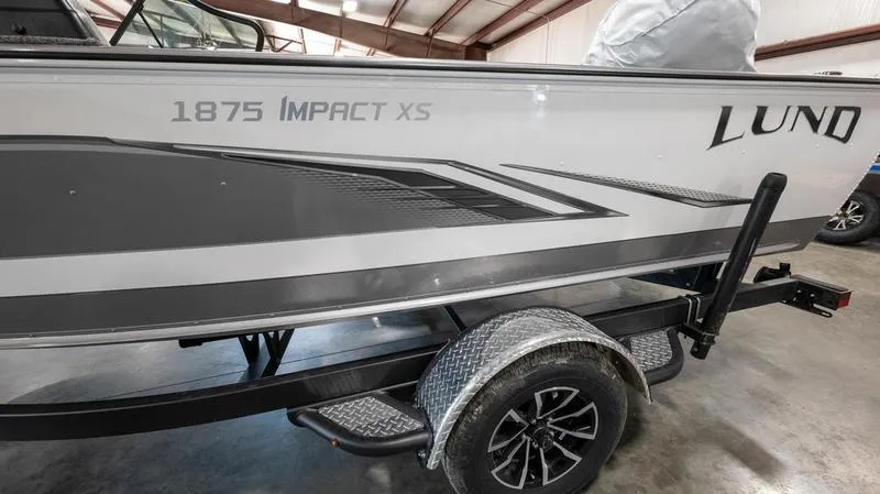 Slide: The Image of 2024 Lund 1875 Impact XS Sport boat on trailer in warehouse. - 8