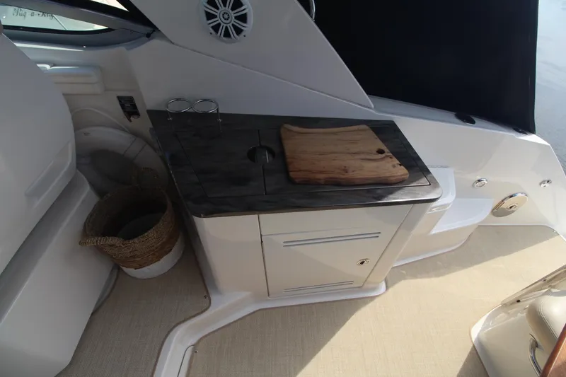 Slide: The Image of Interior of 2014 Sea Ray 350 Sundancer with kitchenette and cutting board. - 11