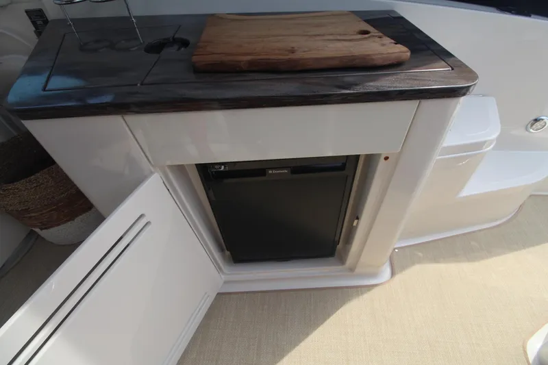 Slide: The Image of 2014 Sea Ray 350 Sundancer interior with mini fridge and wooden countertop. - 15