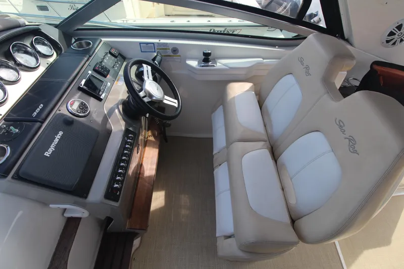 Slide: The Image of 2014 Sea Ray 350 Sundancer helm with dual seats and modern dashboard controls. - 17