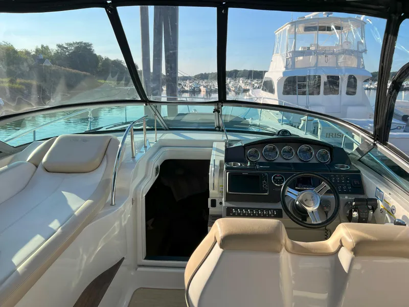 Slide: The Image of 2014 Sea Ray 350 Sundancer cockpit with steering wheel and dashboard, docked in marina. - 20