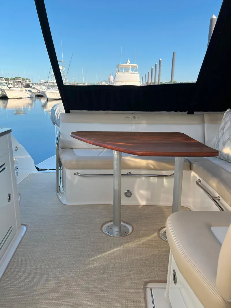Slide: The Image of 2014 Sea Ray 350 Sundancer yacht interior with seating and table, docked at marina. - 23
