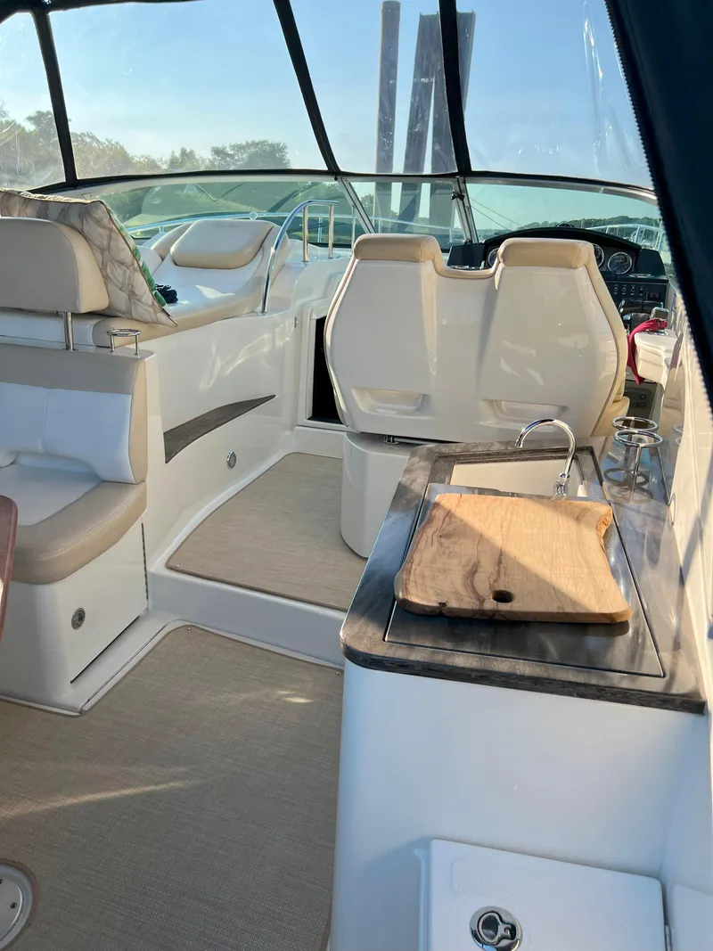 Slide: The Image of 2014 Sea Ray 350 Sundancer interior with seating and kitchenette. - 25