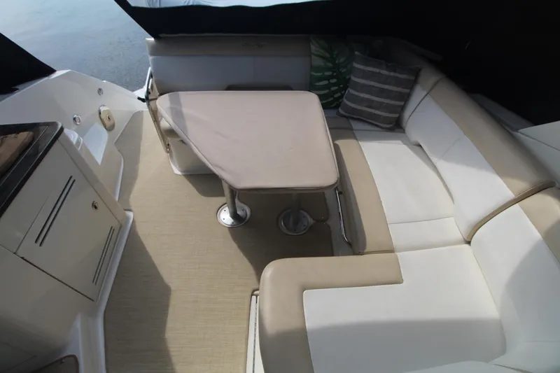 Slide: The Image of 2014 Sea Ray 350 Sundancer interior with beige seating and table. - 26