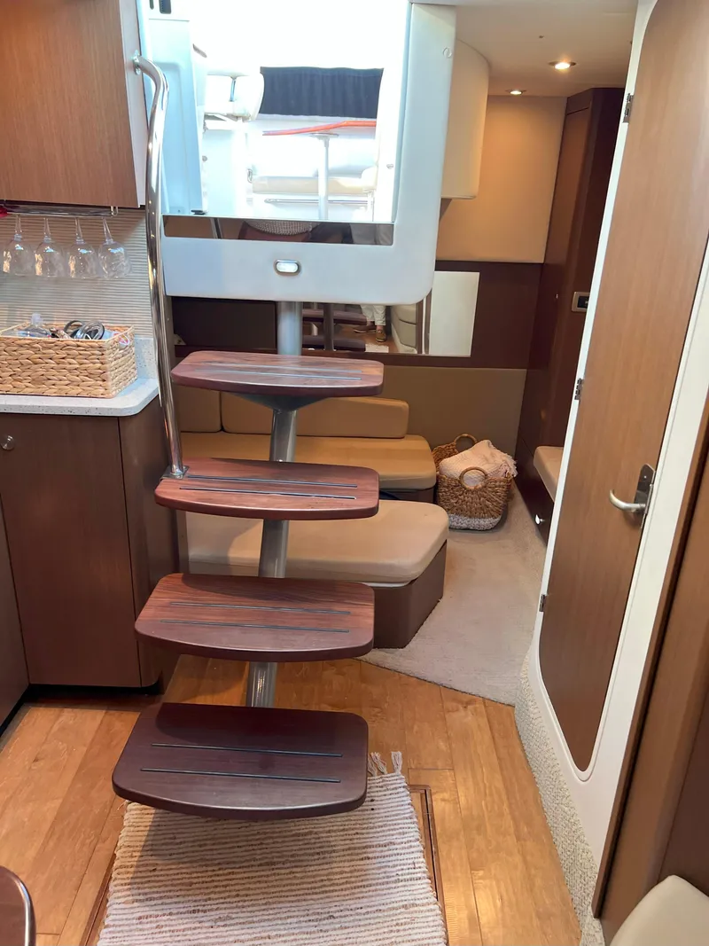 Slide: The Image of Interior of 2014 Sea Ray 350 Sundancer yacht with wooden steps and cozy seating area. - 30