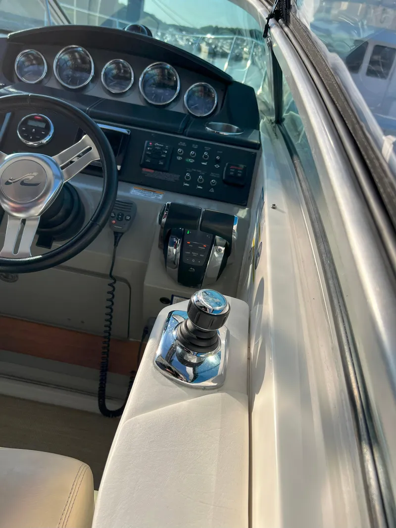 Slide: The Image of 2014 Sea Ray 350 Sundancer helm with steering wheel and control panel. - 31