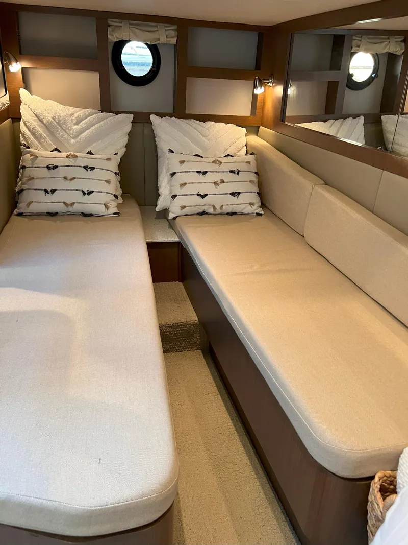 Slide: The Image of 2014 Sea Ray 350 Sundancer cabin with twin beds and decorative pillows. - 34