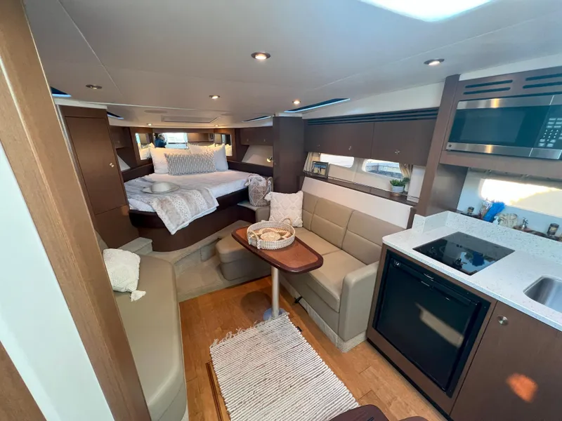 Slide: The Image of Interior of 2014 Sea Ray 350 Sundancer yacht with modern kitchen and cozy seating area. - 38