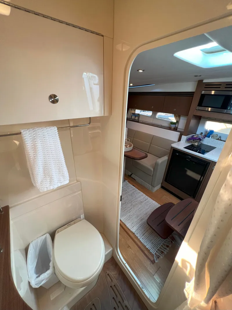 Slide: The Image of 2014 Sea Ray 350 Sundancer interior with bathroom and cozy living area. - 43