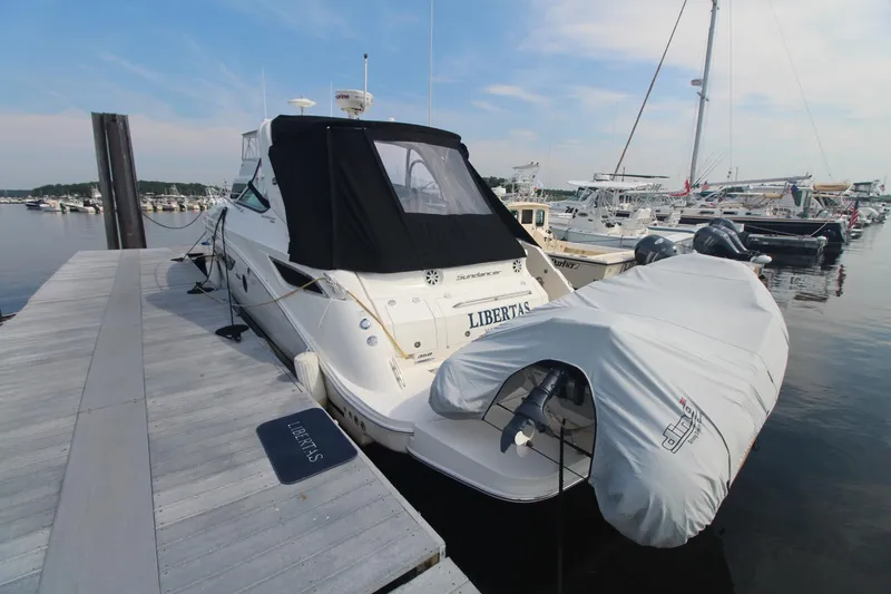 Slide: The Image of 2014 Sea Ray 350 Sundancer docked at marina with covered dinghy. - 9