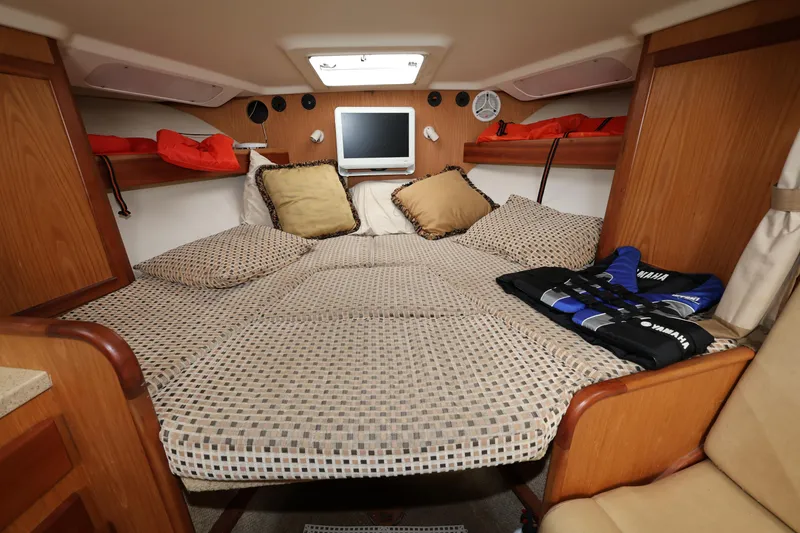 Slide: The Image of 2007 Luhrs 32 Open cabin with bed, TV, and storage shelves. - 27
