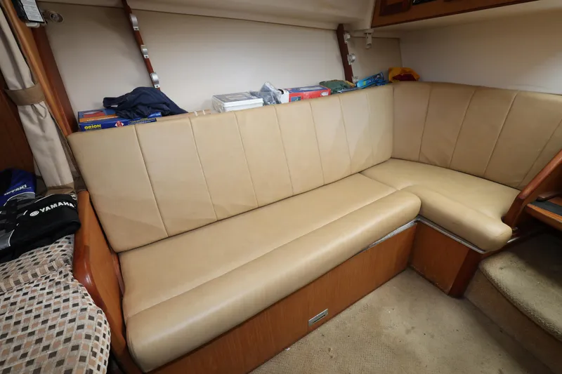 Slide: The Image of 2007 Luhrs 32 Open interior seating area with beige cushions and storage shelves. - 28