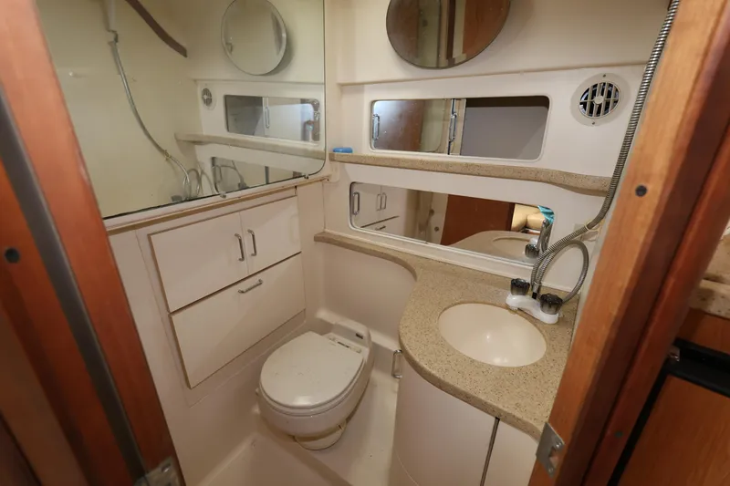 Slide: The Image of 2007 Luhrs 32 Open yacht bathroom with sink, toilet, and storage cabinets. - 30