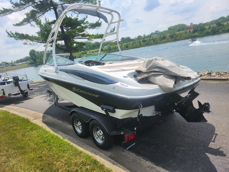 Slide: The Image of 2014 Crownline 21 SS boat on trailer by a river. - 1