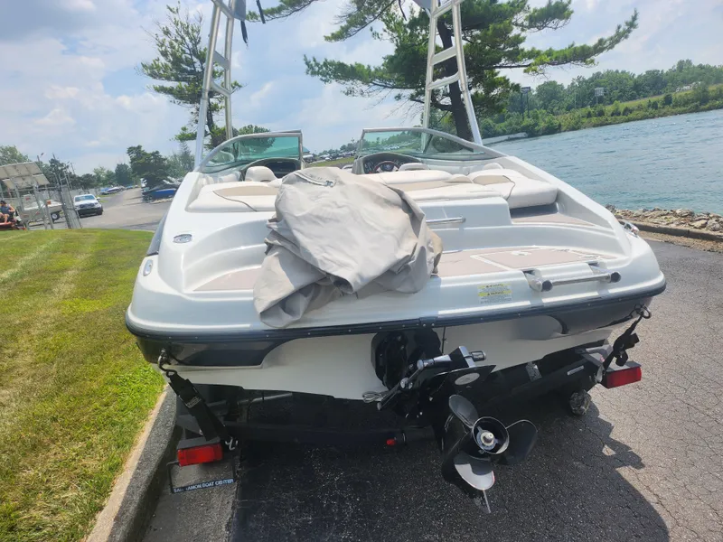 Slide: The Image of 2014 Crownline 21 SS boat parked near a lake, rear view. - 2