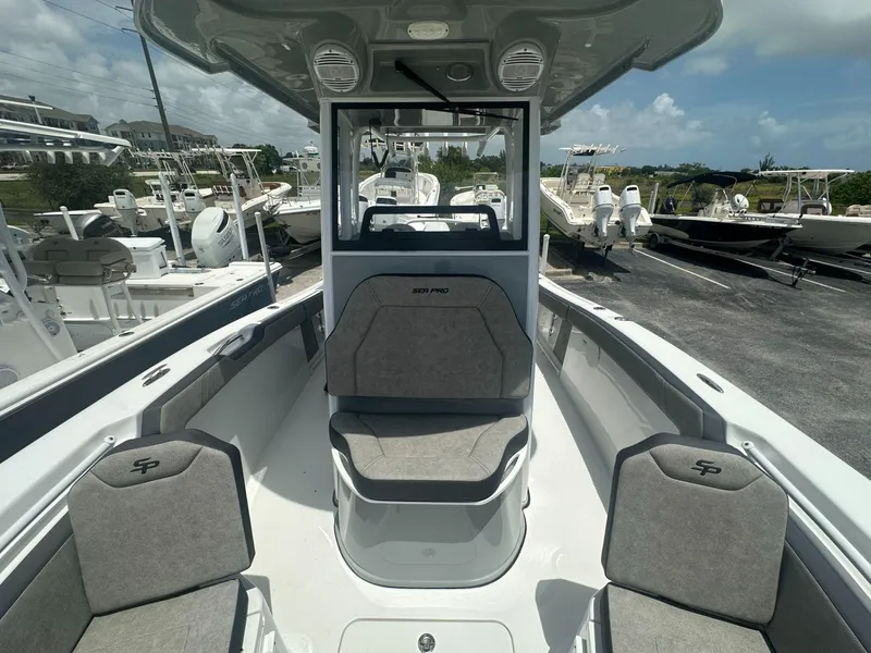 Slide: The Image of 2025 Sea Pro 245 FLX boat interior with seating and console, docked among other boats. - 6