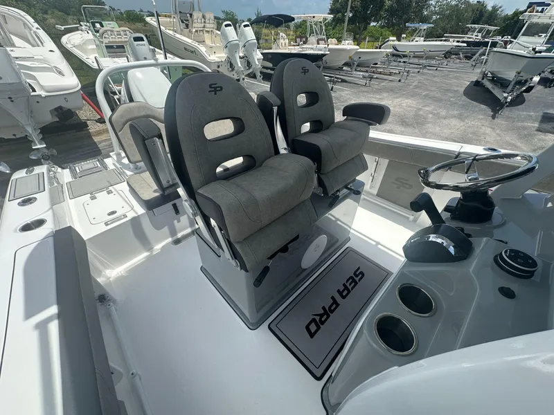Slide: The Image of 2025 Sea Pro 245 FLX boat interior with dual captain's chairs and steering console. - 8