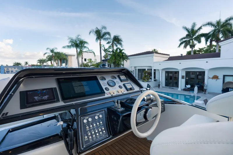 Slide: The Image of Cockpit view of 2012 Riva 75 Venere yacht with luxury villa backdrop. - 46