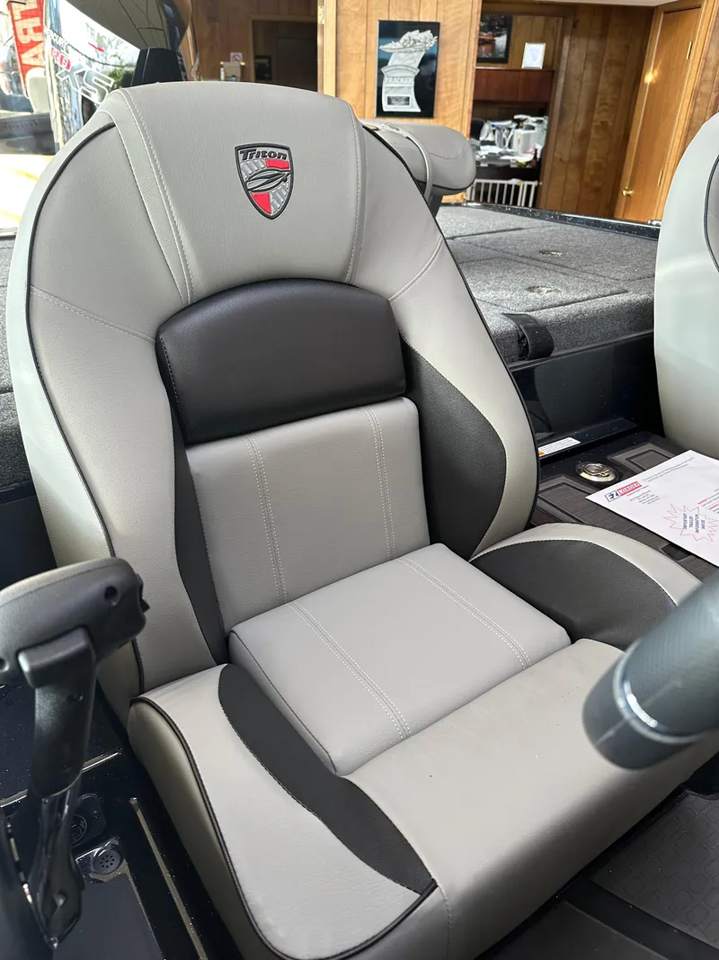 Slide: The Image of 2024 Triton 20XP Patriot boat seat, gray and black design, with logo emblem. - 13