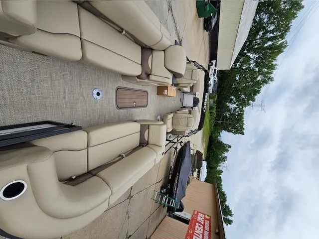 Slide: The Image of 2024 Regency 230 DL3 pontoon boat with beige seating and spacious deck. - 3
