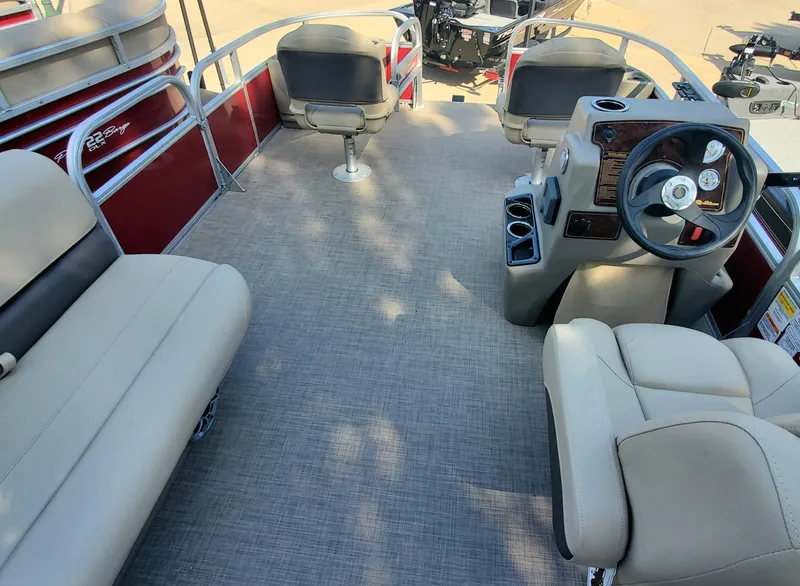 Slide: The Image of 2024 Sun Tracker Bass Buggy 18 DLX pontoon boat interior with seating and steering console. - 2