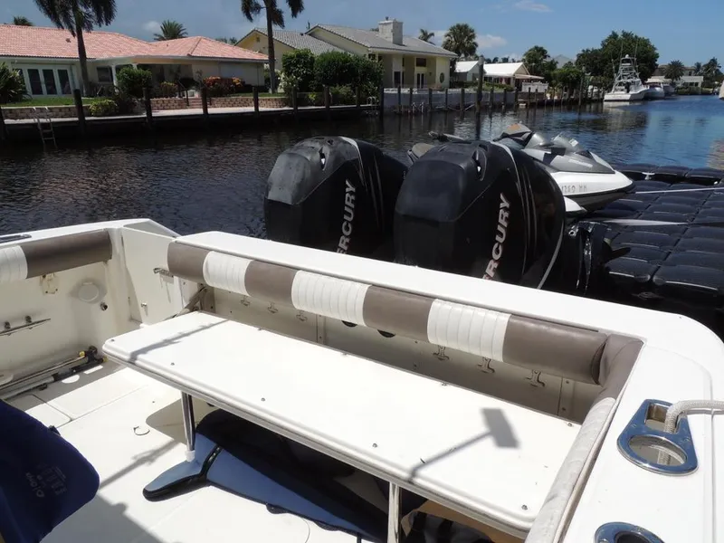 Slide: The Image of 2006 Boston Whaler 320 Outrage Cuddy Cabin with Mercury engines docked by waterfront homes. - 13