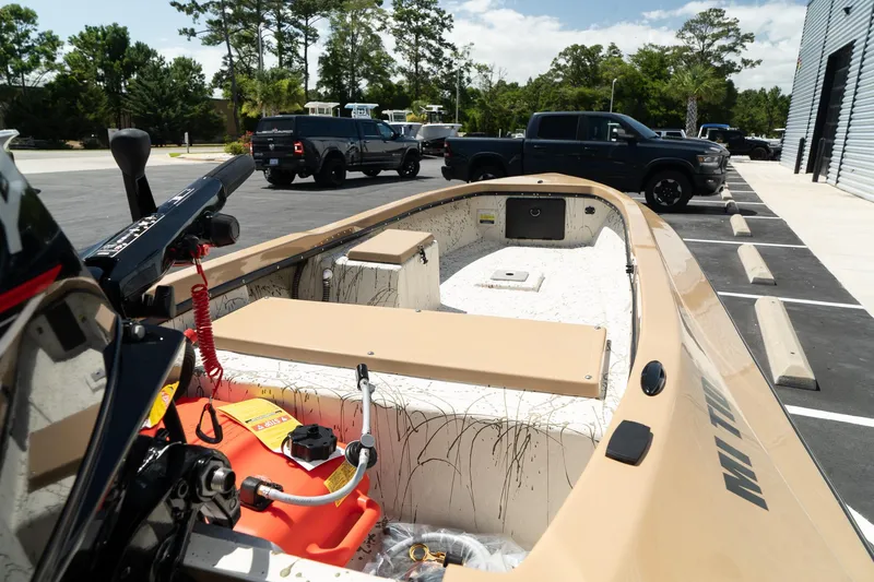 Slide: The Image of 2024 Mi Tide V1408 boat in parking lot with trucks in the background. - 7