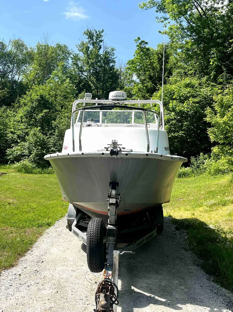 Slide: The Image of 1990 MTI 26-Foot US NAVY Personnel Boat on trailer in a lush green setting. - 11